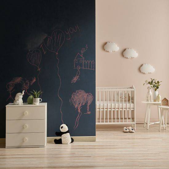 A wall in front of a nursery covered in chalkboard vinyl film and filled with drawings.