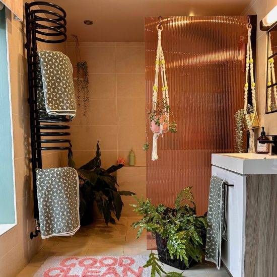 Coral reeded window film added to a shower screen in a light bathroom with cute decor.
