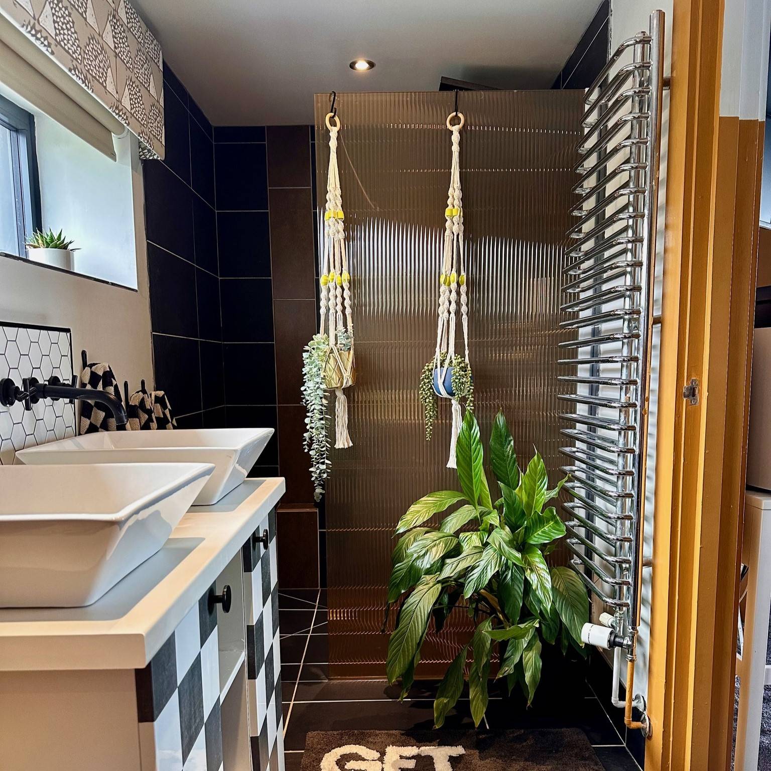 Tangerine reeded window film installed in a bathroom with dark tiles.