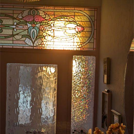 Maureen stained glass window film installed with a sunset behind.