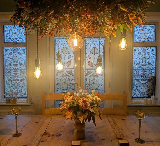 Tatia stained glass window film design in a dining room with floral decor