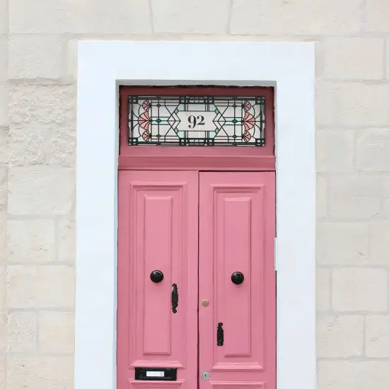 Beatrice stained glass door number window film installed above a pink door.
