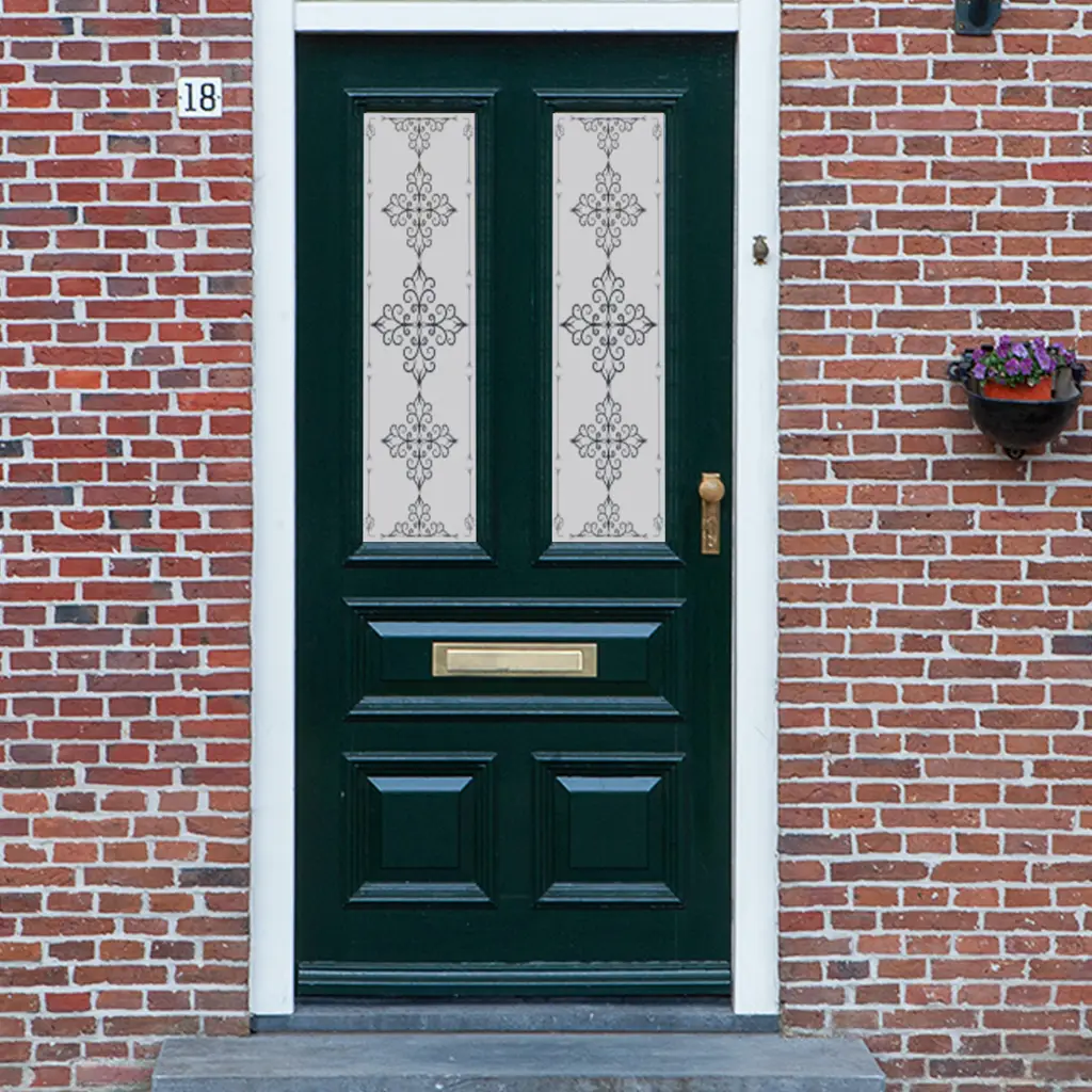 An ornate cross design in a Victorian frosted door window film installed on an old door