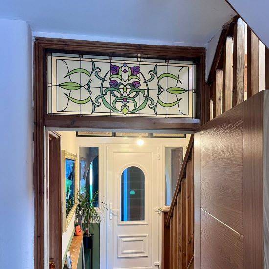 Cynthia stained glass window film installed above an internal door with a dark wood frame