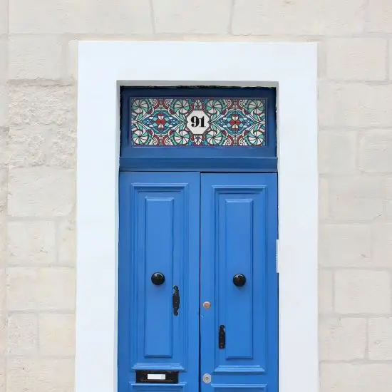 Harold stained glass door number design above a blue door