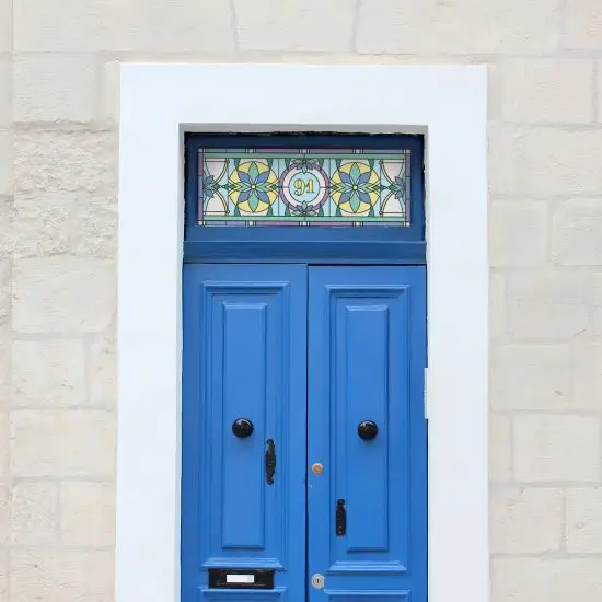 Harry flower stained glass window film with a central door number installed above a blue front door