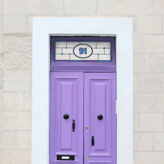 Ingrid stained glass design with a central door number installed above a purple front door