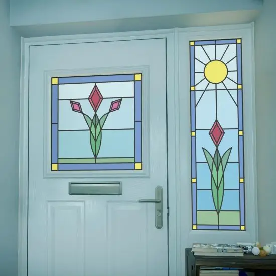 A simple stained glass design with a red flower and the sun with a sky blue background installed onto a front door.