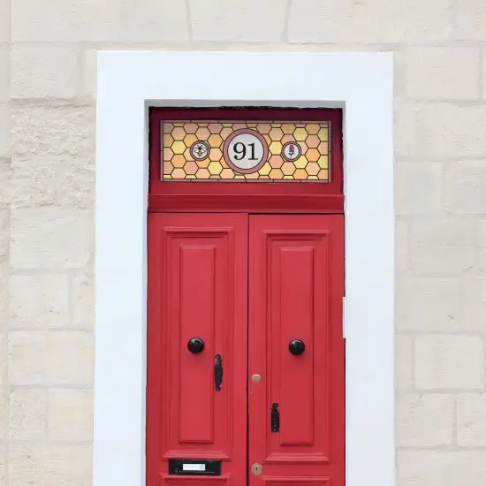 Honey comb stained glass window film in orange and yellow with a central door number