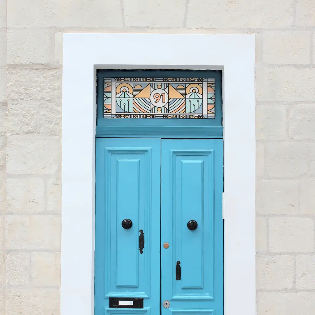 Dawn stained glass house number with blue and pastel yellow colouring installed above a light blue door.