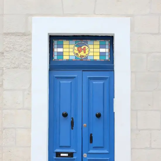 stained glass window film with central door number on a blue door