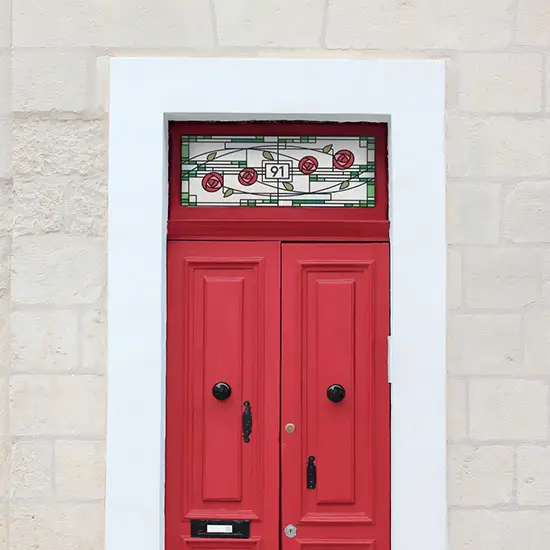 Yoko stained glass window film design with a door number in the middle above a red door